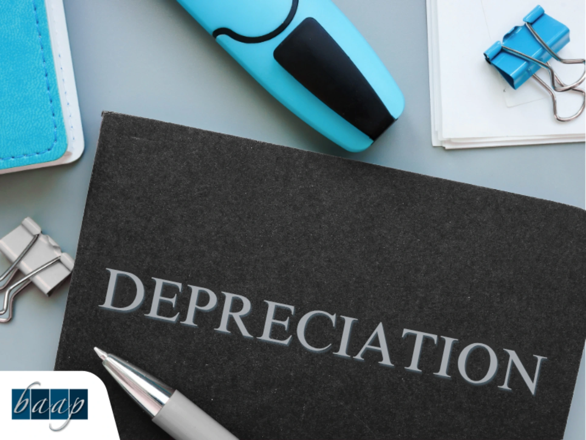 Depreciation booklet on desk with office supplies for business tax planning